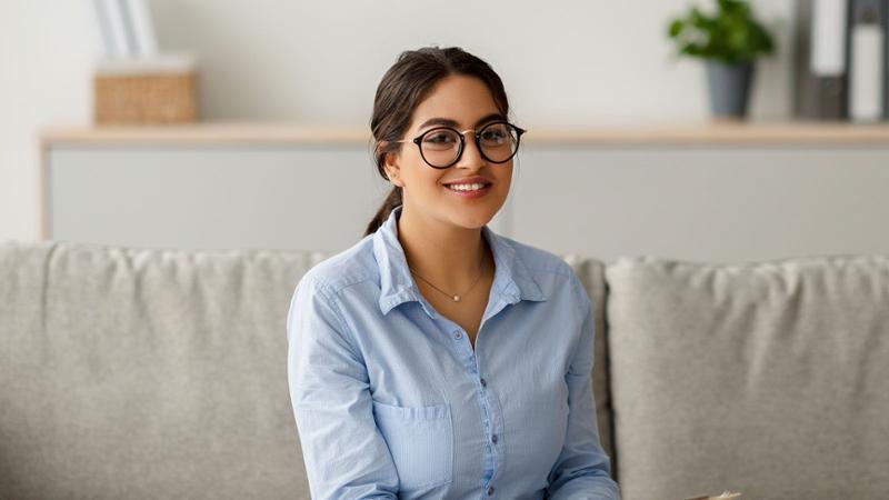 Young woman on couch with glasses